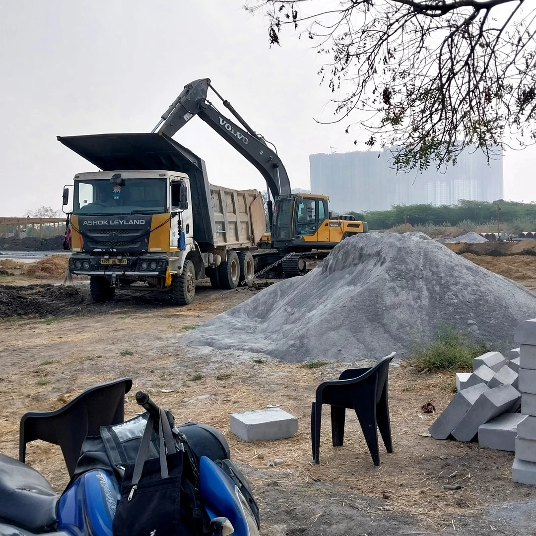 Gravel Dumping Earthmoving equipment loading construction debris and soil into a dump truck near large gravel piles at Prestige Golden Grove