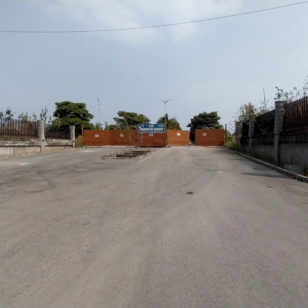 Site Entrance Gate View View of the main access road and site barriers at the Prestige Golden Grove project site in Hyderabad